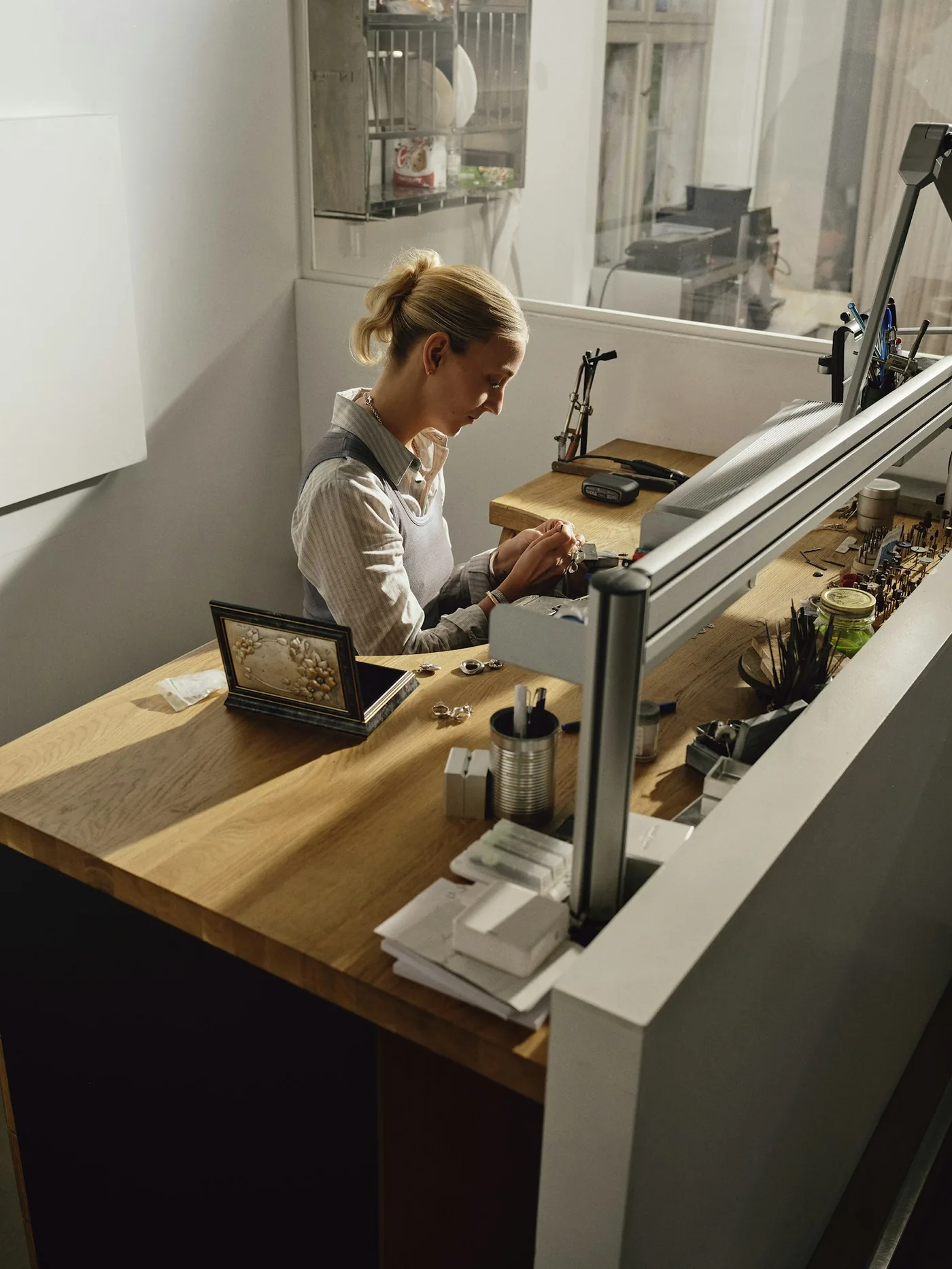 A shop owner working on a laptop behind the front counter