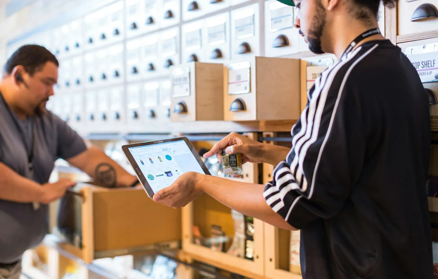 Two people checking something on a tablet while working on a shop floor