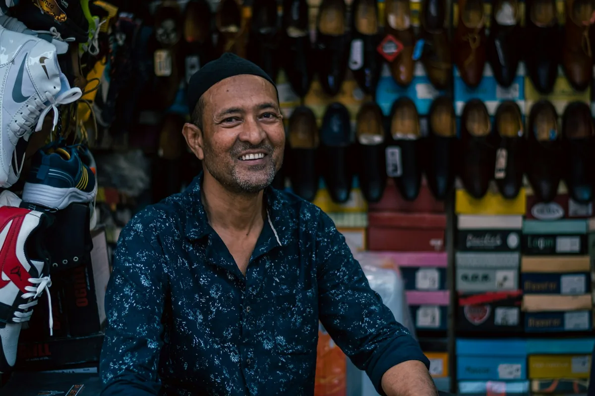 An independent shop owner smiling behind their counter