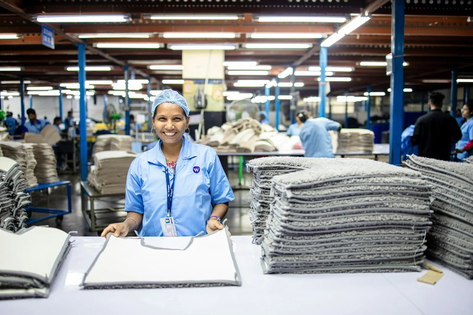 A commercial laundry floor with finished orders stacked at a folding table